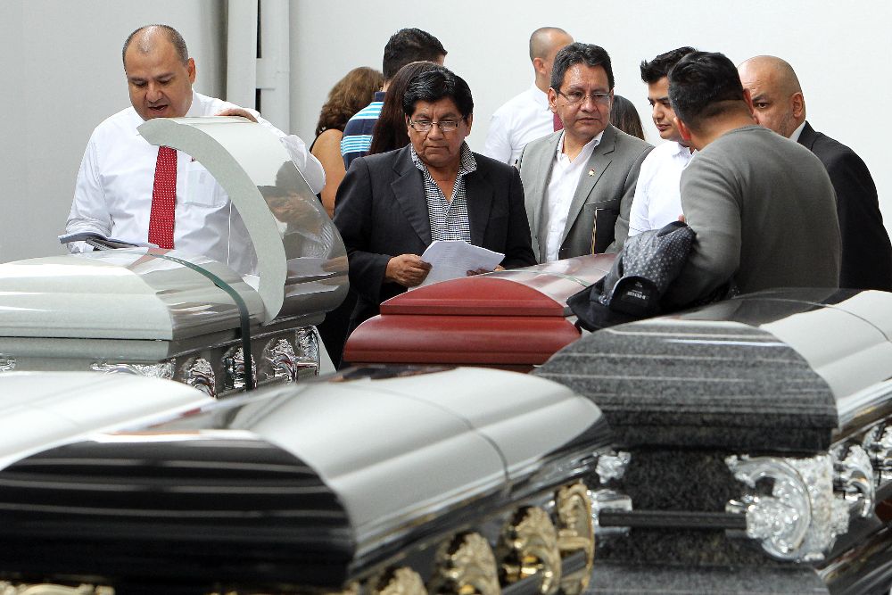 El viceministro de Gobierno de Bolivia, Pedro Villa (2i), llega a la Funeraria San Vicente durante los preparativos para el velatorio de las víctimas del accidente aéreo de la compañía aérea boliviana Lamia.