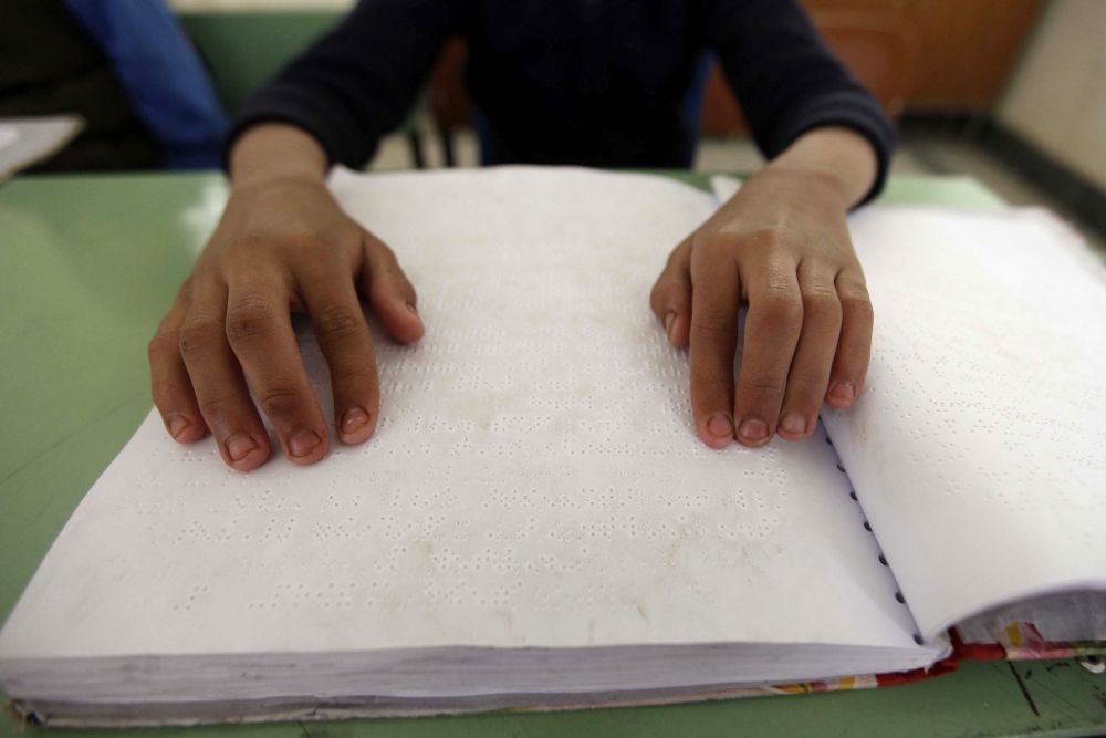 Un niño ciego aprende a leer en braille.