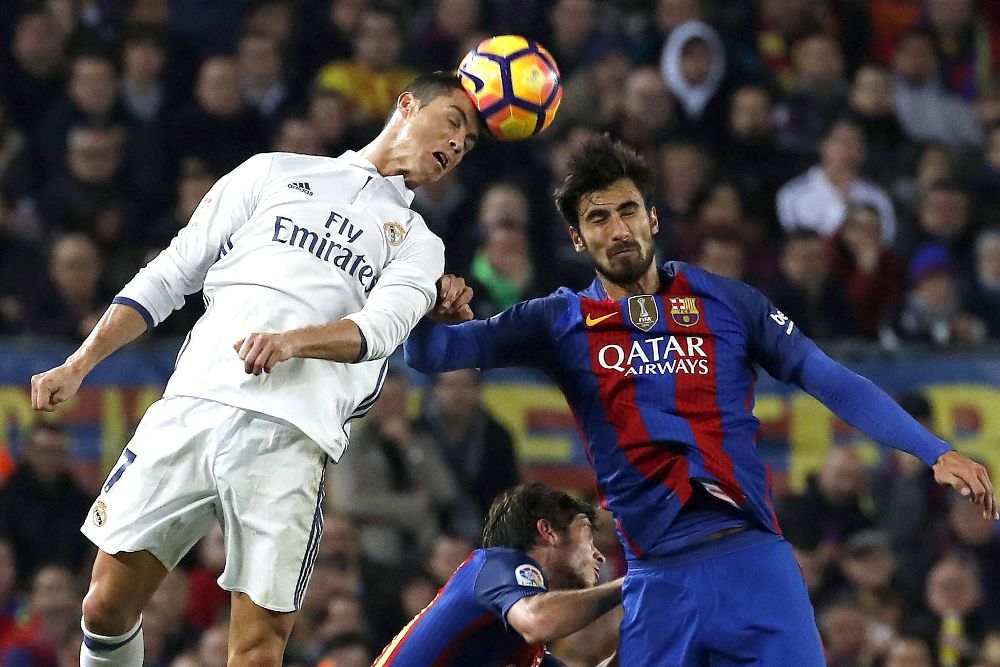 El centrocampista portugués del FC Barcelona, André Gomes (d) lucha por el balón con el delantero portugués Cristiano Ronaldo, del Real Madrid, durante el partido.