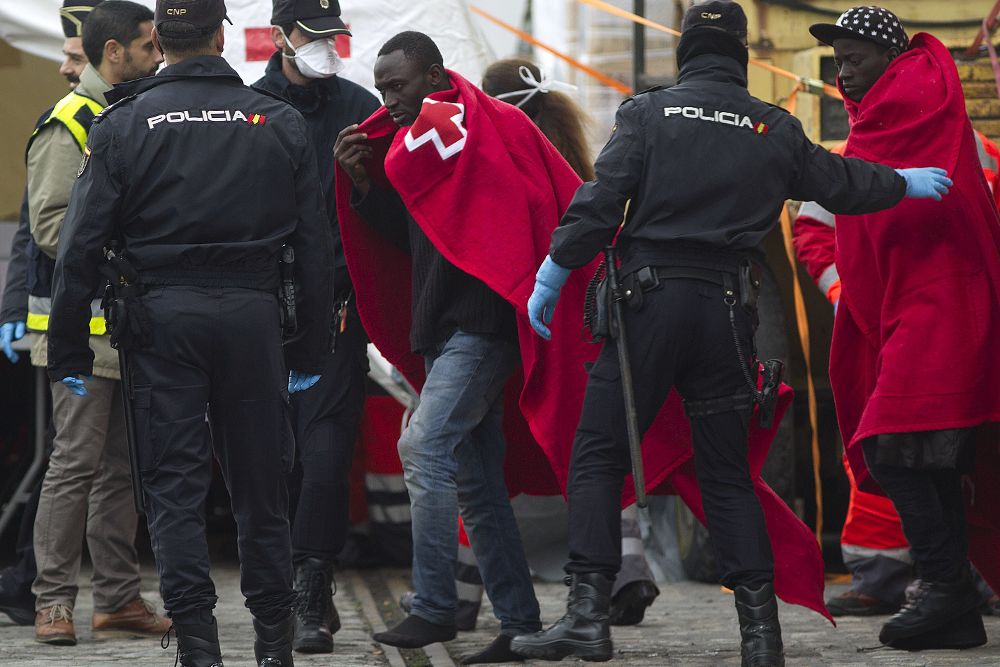 Varios de los 53 inmigrantes que han sido rescatados a 49 millas al sur de Málaga a su llegada al puerto de Málaga.