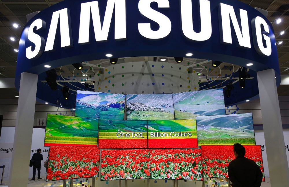 Un visitante coreano observa varias pantallas de televisión Samsung en la Gran Feria de Electrónica de Corea en Seúl (Corea del Sur).