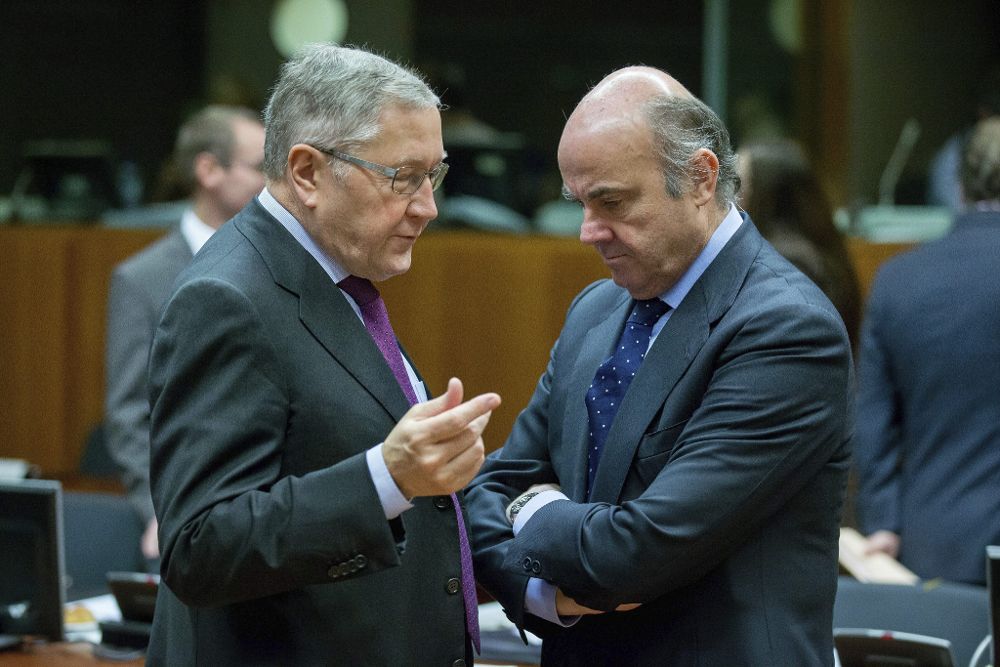 El ministro español de Economía, Luis de Guindos (d), conversa con el director gerente del Mecanismo de Estabilidad, Klaus Regling, a su llegada a la reunión de ministros de Economía y Finanzas de la Unión Europea.