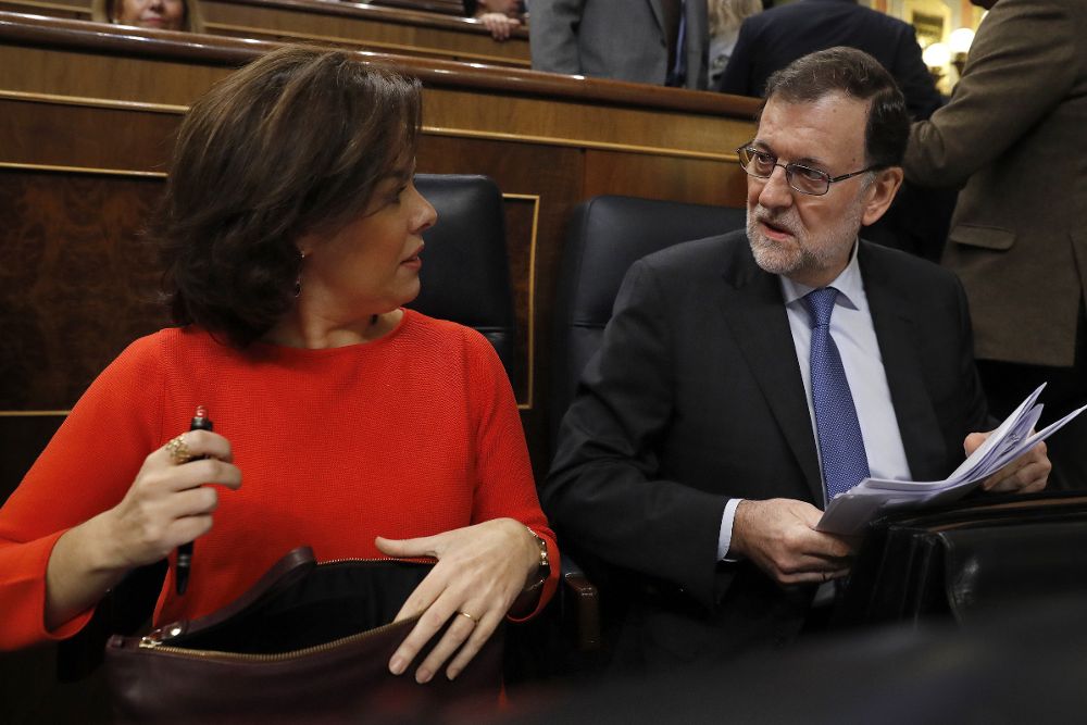 El presidente del Gobierno, Mariano Rajoy (d), conversa con la vicepresidenta, Soraya Sáenz de Santamaría (i), al inicio de la primera sesión de control al Gobierno.