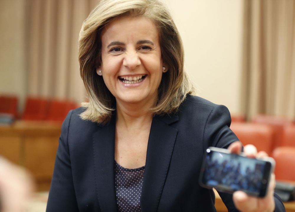 La ministra de Empleo, Fátima Báñez, muestra la foto que ha hecho con su teléfono móvil a los fotógrafos, antes de su comparecencia en la Comisión de Empleo y Seguridad Social, esta mañana en el Congreso de los Diputados.