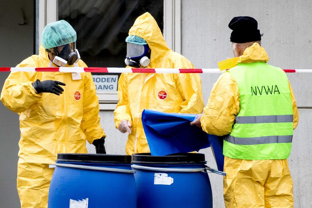 Empleados de la Sanidad con máscaras protectivas están evacuando una granja de patos tras detectarles la gripe aviar.