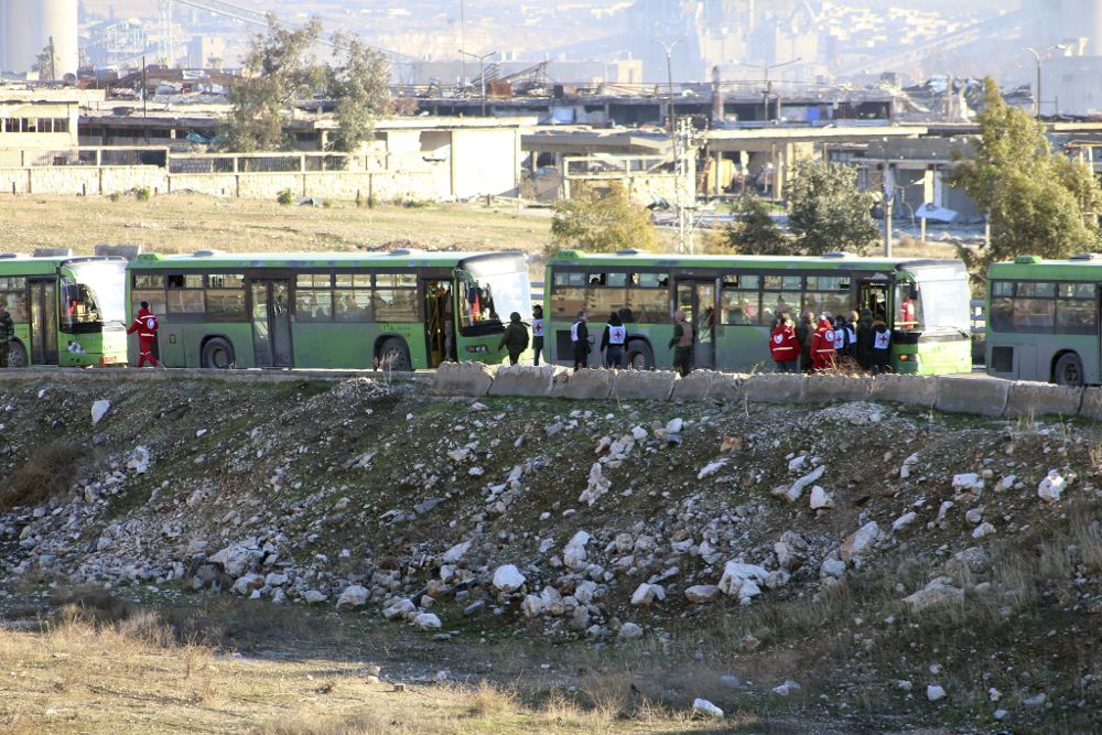 Autobuses del gobierno esperan a llevar a cabo la evacuación de los combatientes, sus familiares y civiles que se encuentran en los barrios rebeldes en Alepo, Siria.