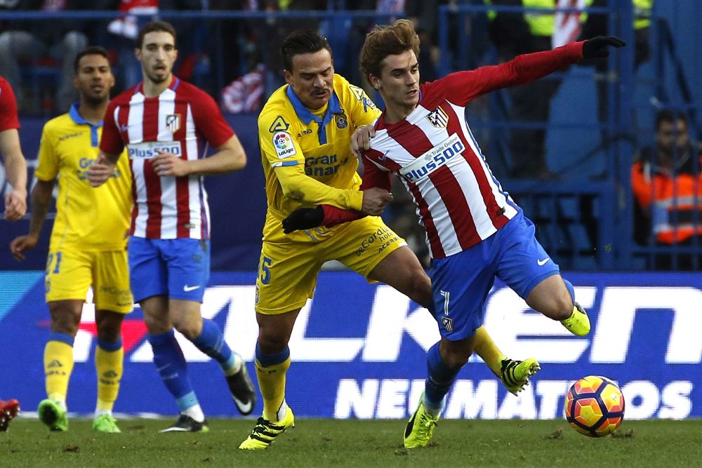 El delantero francés del Atlético de Madrid Antoine Griezmann (d) disputa un balón con el centrocampista de Las Palmas Roque Mesa.