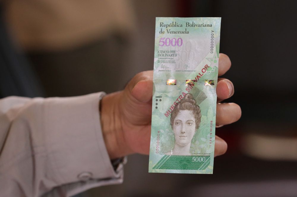 Fotografía cedida por el Palacio de Miraflores donde se observa al presidente de Venezuela Nicolas Maduro sosteniendo un billete de 5.000 bolívares.