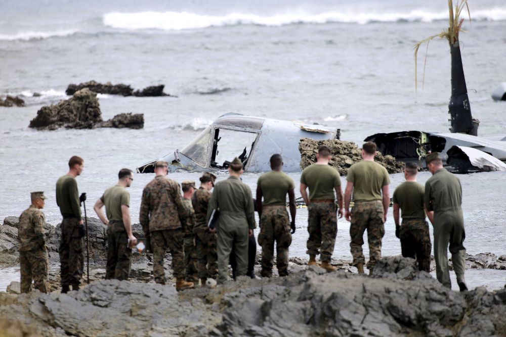 Militares estadounidenses inspeccionan los restos de un avión militar estadounidense Osprey que se estrelló en Nago.