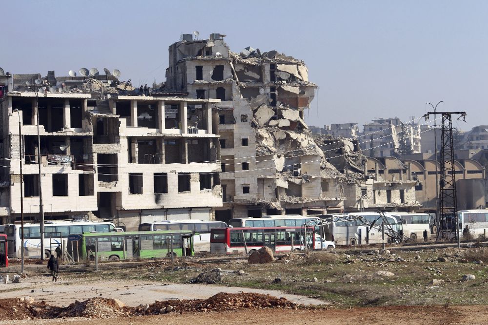 Unos autobuses esperan para transportar a un grupo de combatientes opositores de los distritos sitiados de la mitad oriental de Alepo y a sus familiares hacia los barrios del este.