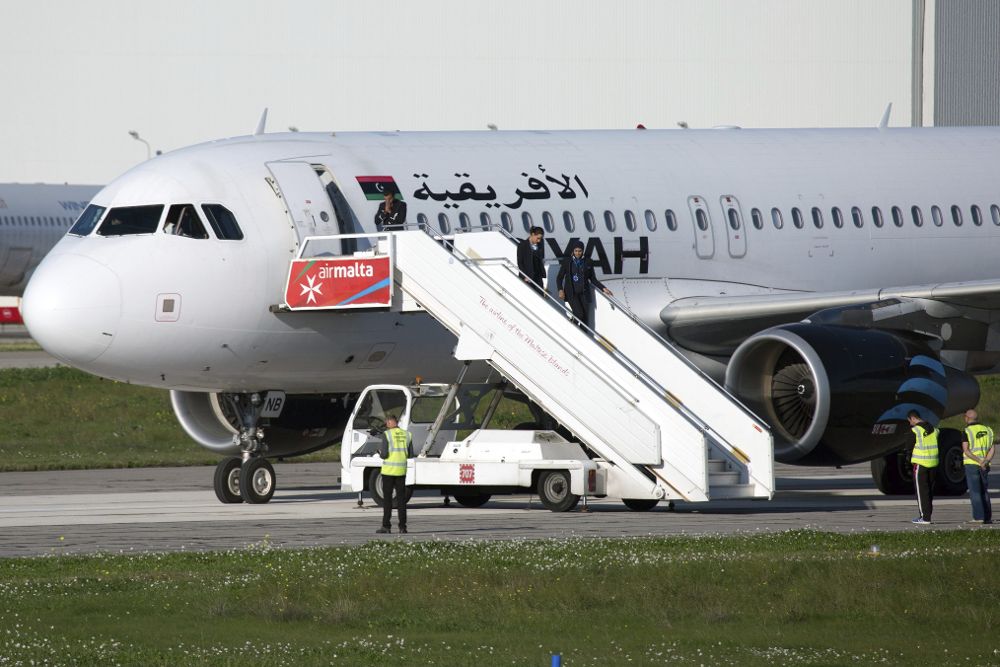 Las azafatas salen del avión de la compañía libia Afriqiyah Airways que fue secuestrado cuando realizaba un vuelo interno con 109 pasajeros a bordo y desviado a la isla de Malta.