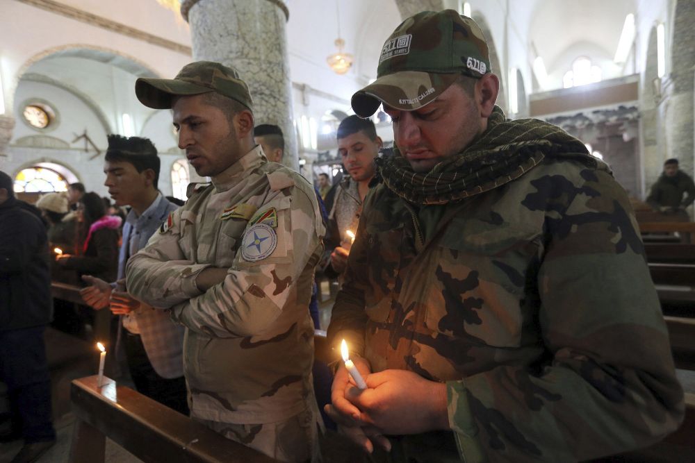 Soldados iraquíes asisten a la misa de Navidad en la iglesia de Al-Tahira Al-Kubra al este de Mosul, Irak.