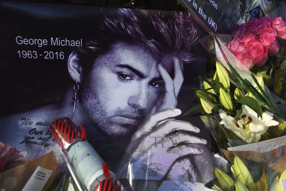 Flores y mensajes depositados a las puertas de la residencia del cantante británico George Michael en Londres sobre una foto suya.