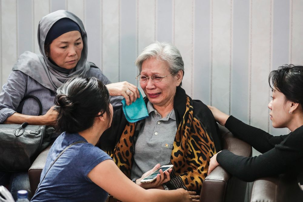 Varias mujeres consuelan a una familiar durante el proceso de identificación de las víctimas del barco en un hospital de la policía en Yakarta (Indonesia).