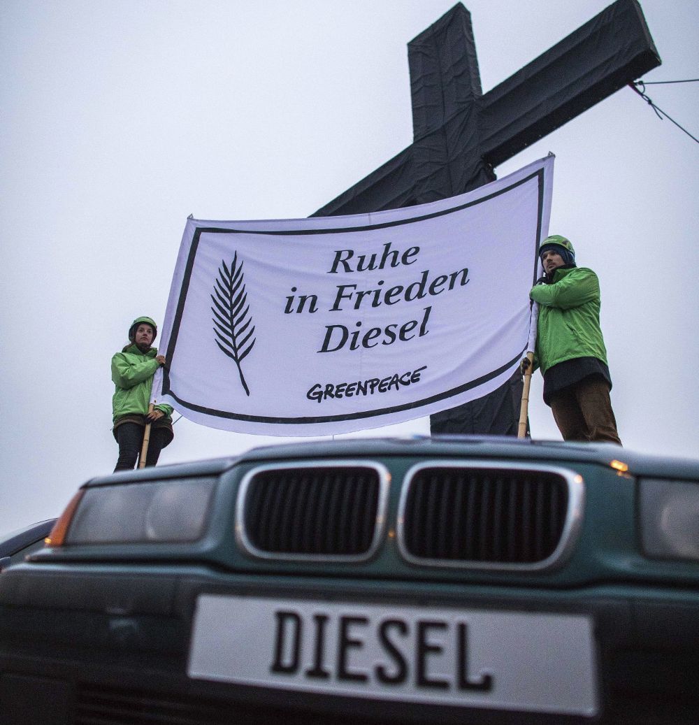 Activistas de Greenpeace sostienen un cartel en el que se lee "Descansa en paz, Diésel" durante un acto de protesta en frente de unas oficinas del grupo automovilístico Volkswagen en Wolfsburgo, Alemania.