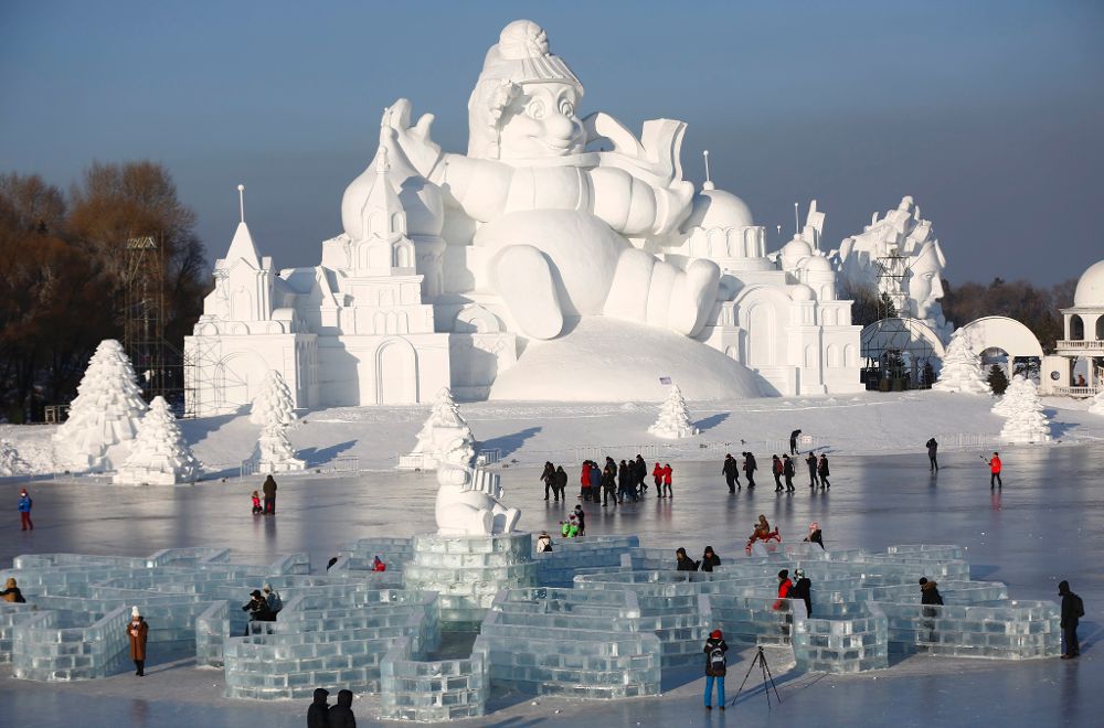 Varias personas visitan una escultura de nieve de 35 metros de alto en la trigésimo tercera edición del Festival Internacional de Hielo y Nieve de Harbin (China) hoy, 5 de enero de 2017.
