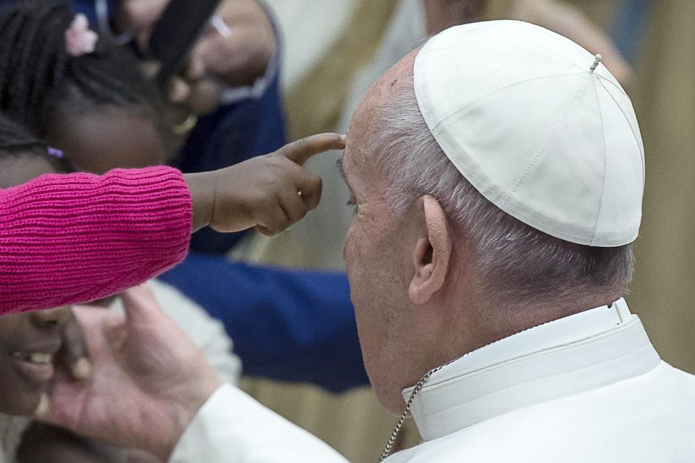 El papa Francisco se detiene a saludar a una niña.