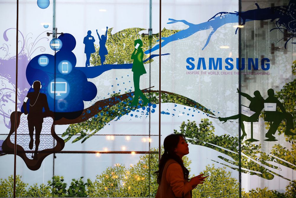 Una mujer camina junto a una publicidad de Samsung.