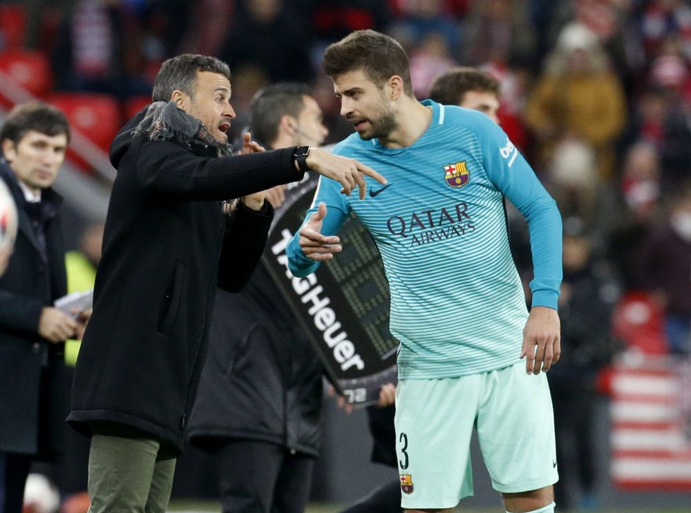 El defensa del F.C Barcelona, Gerard Piqué (d), recibe indicaciones del técnico del equipo barcelonista, Luis Enrique.
