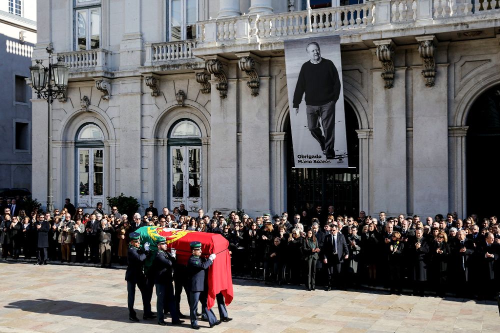 El féretro con los restos mortales del expresidente Mario Soáres es portado a hombros durante una una parada en el Ayuntamiento de Lisboa.