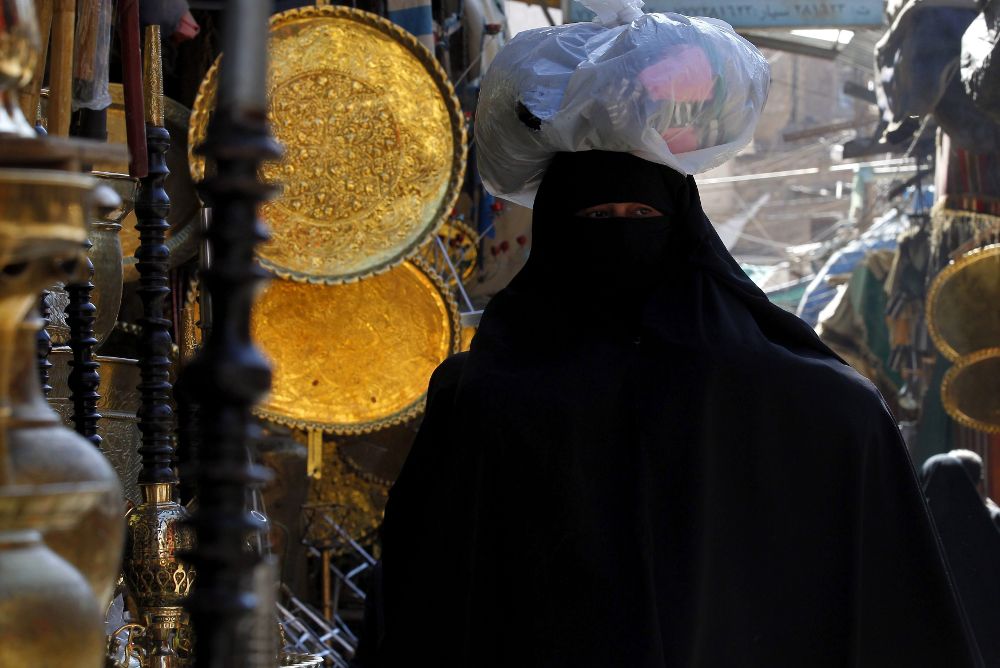 Una mujer con burka hace la compra en un mercado.