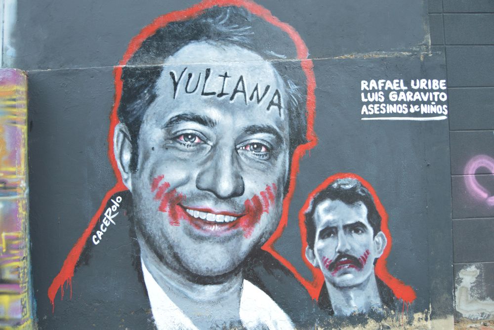 Grafiti con el retrato de Rafael Uribe Noguera (i), el asesino confeso de la niña Yuliana Samboní, junto a uno pequeño de Luis Alfredo Garavito (d), un preso colombiano considerado como el confeso mayor asesino en serie de niños del mundo.