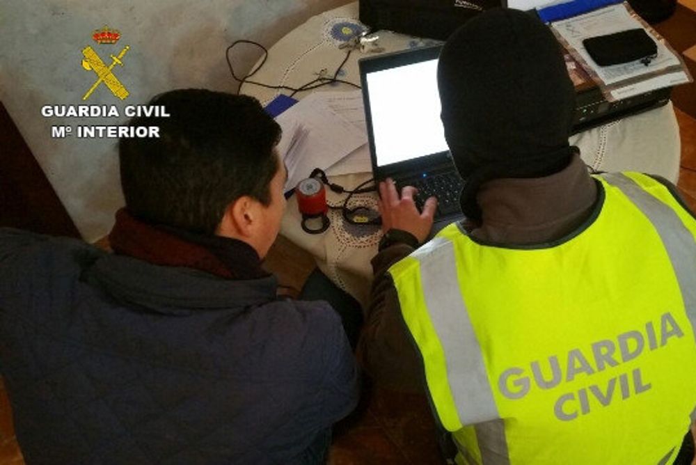 En la foto, efectivos de la Guardia Civil inspeccionan un ordenador durante los registros.