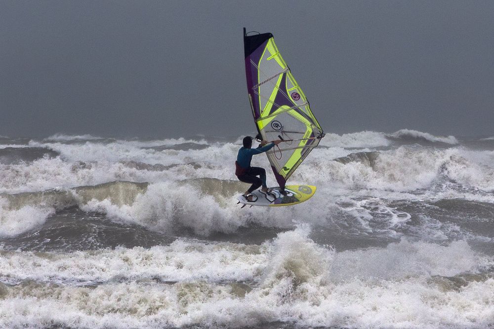 Un joven aprovecha las condiciones climáticas para practicar windsurf en Port Saplaya, Valencia.