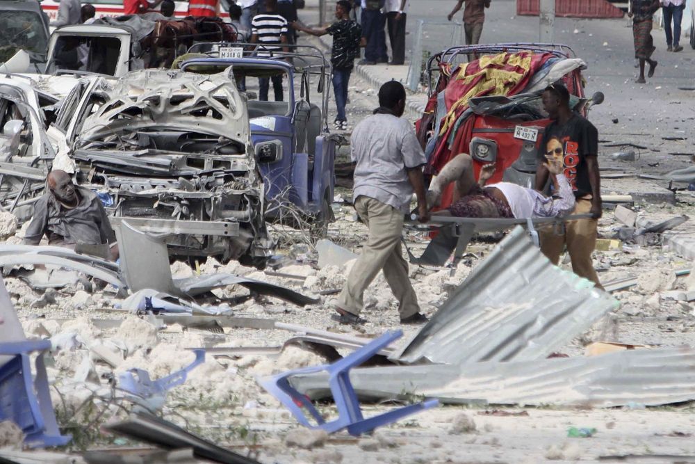 Un hombre herido recibe ayuda tras ell atentado en el Hotel Dayah cerca del Parlamento en Mogadiscio.