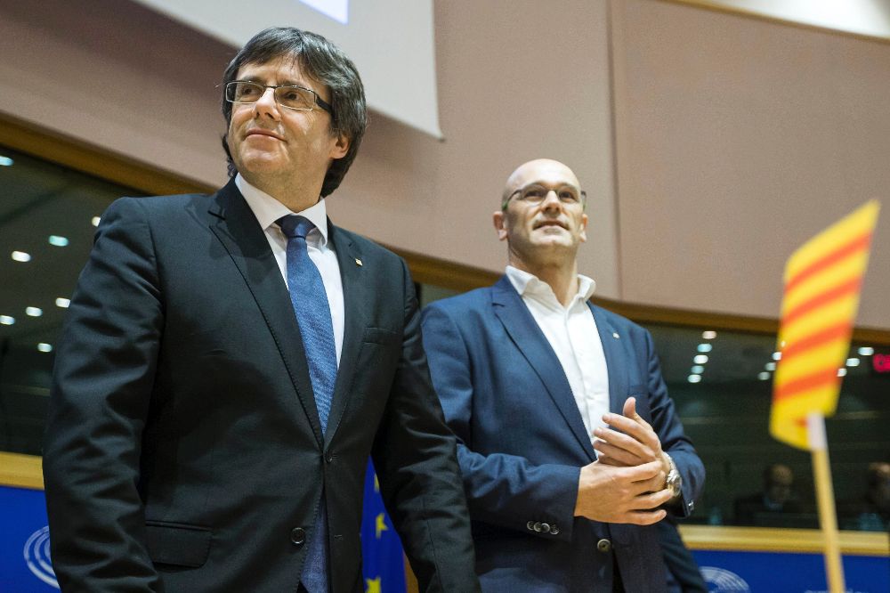 El presidente, Carles Puigdemont (i), y el conseller de Exteriores, Raül Romeva (d), durante la conferencia que han ofrecido en las instalaciones del Parlamento Europeo para explicar sus planes sobre la independencia de Cataluña.
