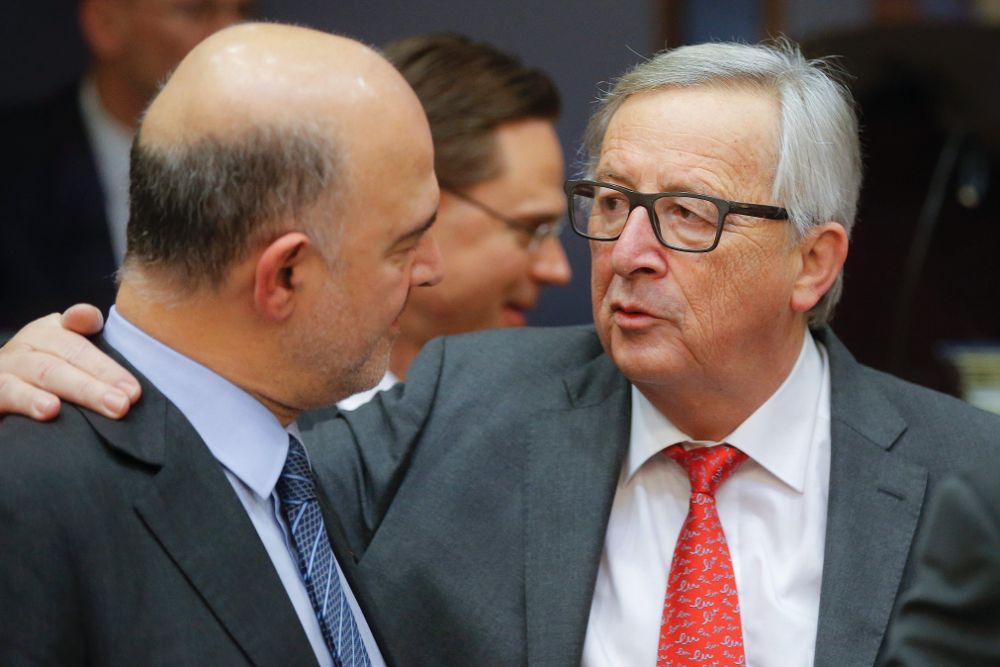 El presidente de la Comisión Europea, Jean-Claude Juncker (d), conversa con el comisario europeo de Economía, el francés Pierre Moscovici.