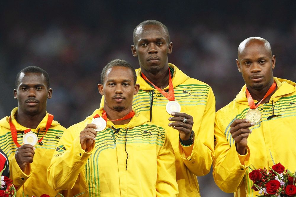 Los atletas jamaicanos (i-d) Nesta Carter, Michael Frater, Usain Bolt, y Asafa Powell mientras posan en el podio con sus medallas de oro tras ganar en la final de relevos 4x100 durante los Juegos Olímpicos de Pekín 2008.