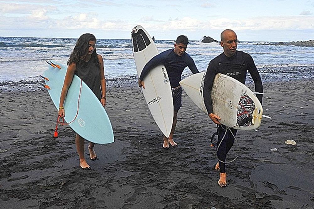 Jonay (delante), Raquel y Borja, surfistas asiduos de la playa.