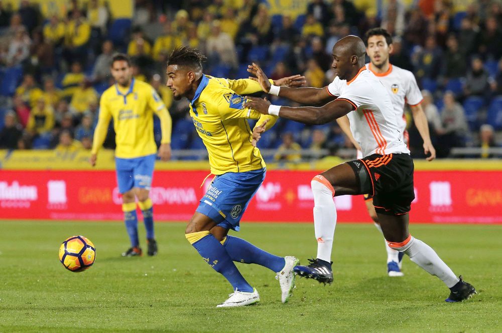 El centrocampista ghanés de la UD Las Palmas, Kevin-Prince Boateng (i), protege el balón ante el defensa francés del Valencia, Eliaquim Mangala (i).