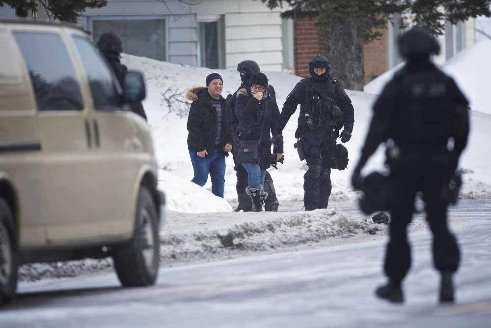 Agentes de policía escoltan a un grupo de personas en la zona del Centro Cultural Islámico que sufrió el ataque terrorista la noche del domingo, en Quebec.