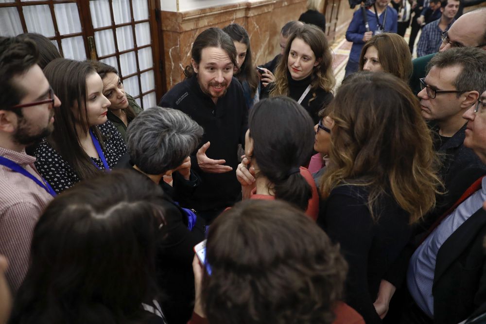 El líder de Podemos, Pablo Iglesias, conversa con los periodistas en los pasillos del Congreso,donde hoy se celebra sesión plenaria de la cámara.