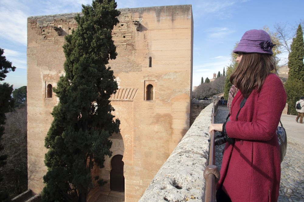 Una turista observa la Torre de la Justicia de la Alhambra de Granada.