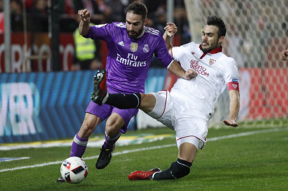 El centrocampista del Sevilla CF Vicente Iborra (d) lucha el balón con Daniel Carvajal, del Real Madrid.
