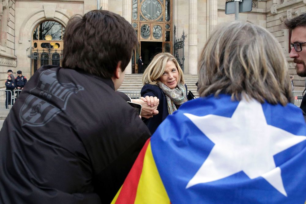 La exvicepresidenta de la Generalitat, Joana Ortega, saluda a varios simpatizantes a las puertas del TSJC durante un receso.