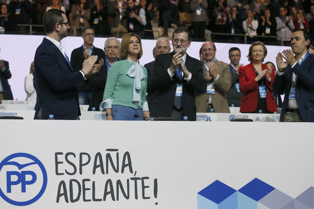 El presidente del PP, Mariano Rajoy (d) y el vicesecretario del PP Fernando Martínez Maillo (i) aplauden a la secretaria general del partido, María Dolores de Cospedal, tras presentar el informe de gestión durante el XVIII congreso nacional que se ha inaugurado esta tarde en la Caja Mágica de Madrid.
