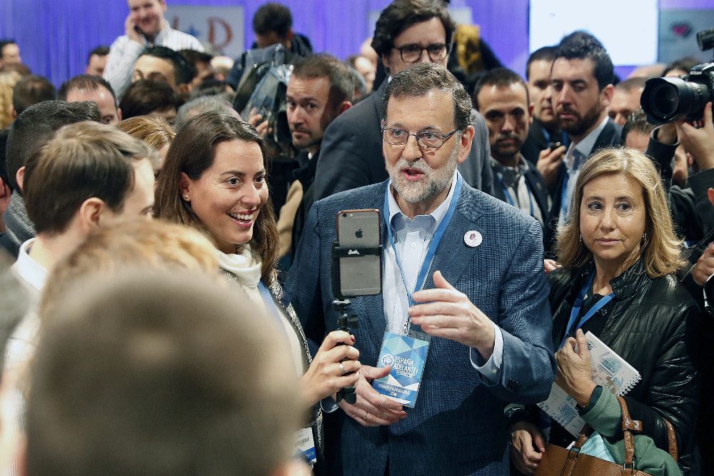 El presidente del Gobierno y líder del PP, Mariano Rajoy (c), se fotografía con una simpatizante a su llegada a la segunda jornada del XVIII Congreso nacional del partido que se celebra en la Caja Mágica, en Madrid.