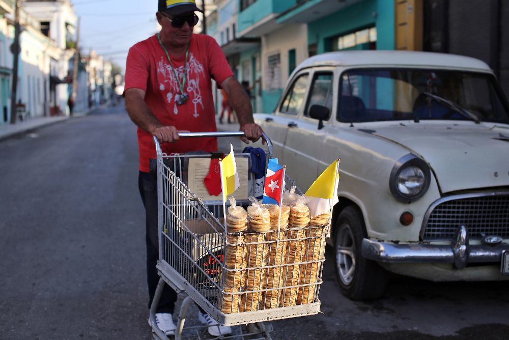 Un hombre vende galletas de producción artesanal en La Habana. En Cuba, la pizza callejera se come sobre un pedazo de papel, al mercado se va con bolsa propia y las botellas de ron se reencarnan en recipientes para salsas.