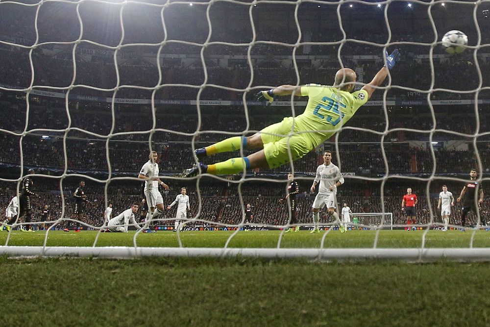 El portero del Nápoles Pepe Reina trata de impedir el tercer gol del Real Madrid,durante el partido de ida de los octavos de final de la Liga de Campeones disputado esta noche en el estadio Santiago Bernabéu, en Madrid.