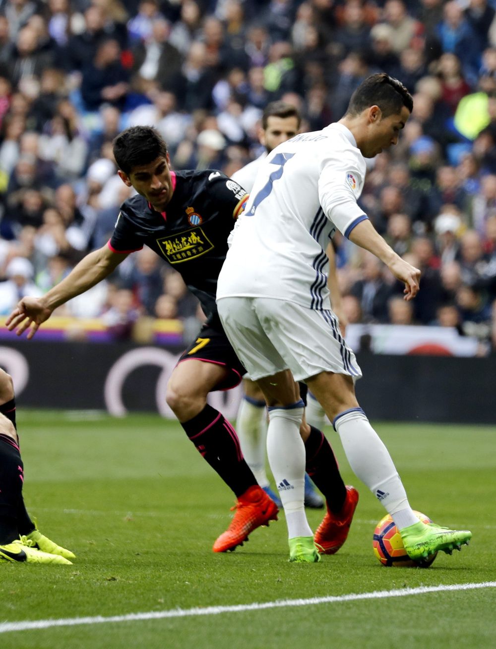 El delantero portugués del Real Madrid Cristiano Ronaldo (d) pelea un balón con el delantero del Espanyol Gerard Moreno.