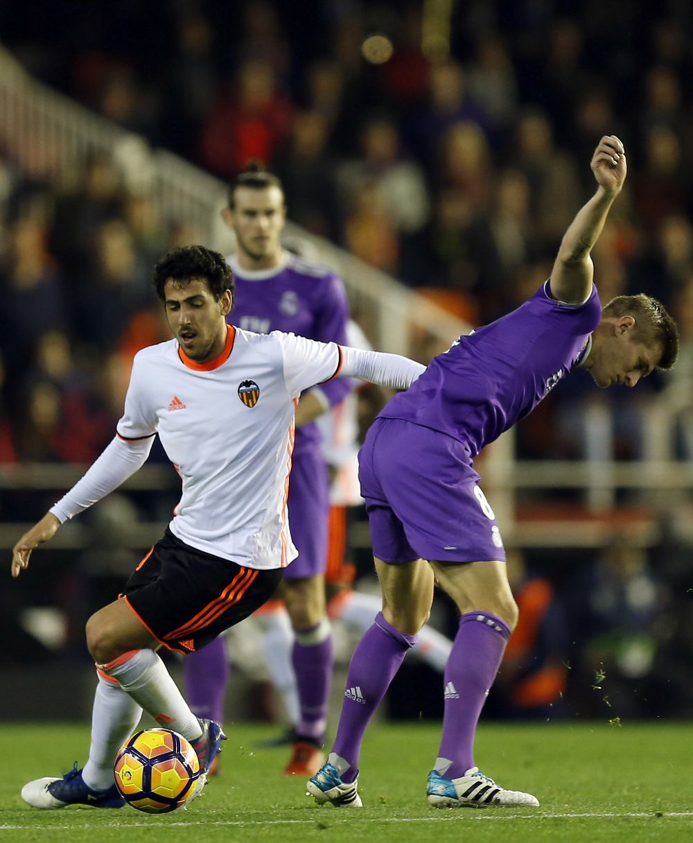 El centrocampista del Valencia CF Daniel Parejo (i) disputa el balón con el alemán Toni Kroos, del Real Madrid.