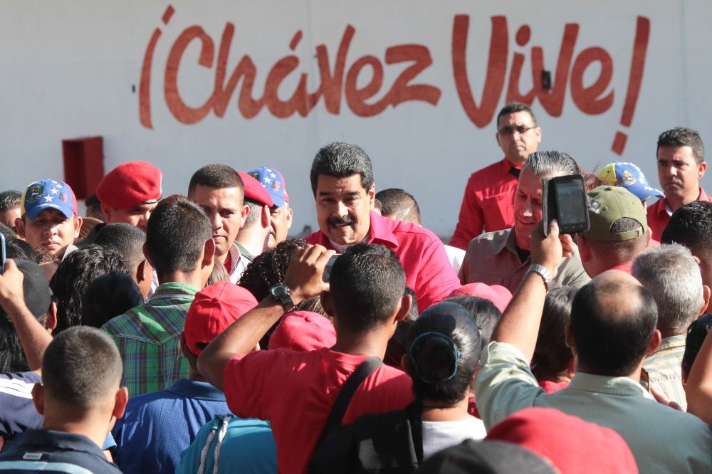 Nicolás Maduro (c)saludando en un acto de gobierno.