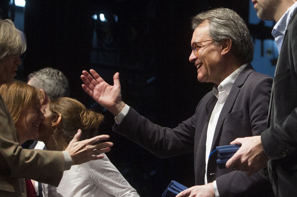 Artur Mas saluda a un nuevo asociado al partido PDeCat en el acto de hoy.