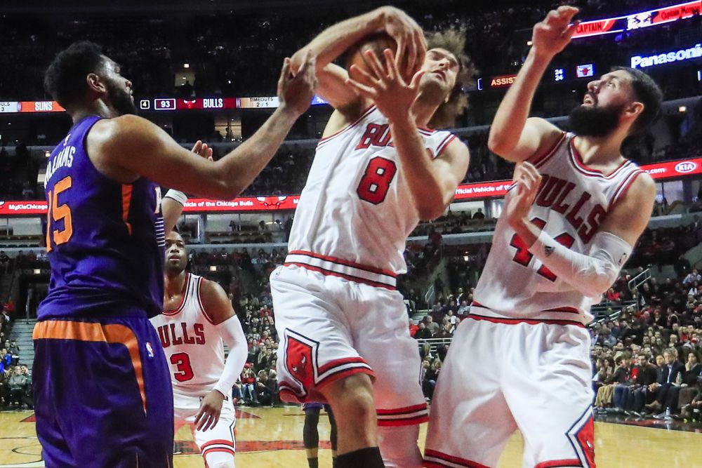 Robin López (C), de Chicago Bulls, captura un rebote entre Alan Williams (i), de Phoenix Suns, y su compañero, el español Nikola Mirotic.