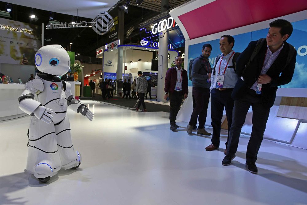 Unos visitantes observan a un robot bailando en el estand de China Mobile en el Congreso Mundial de Móviles.