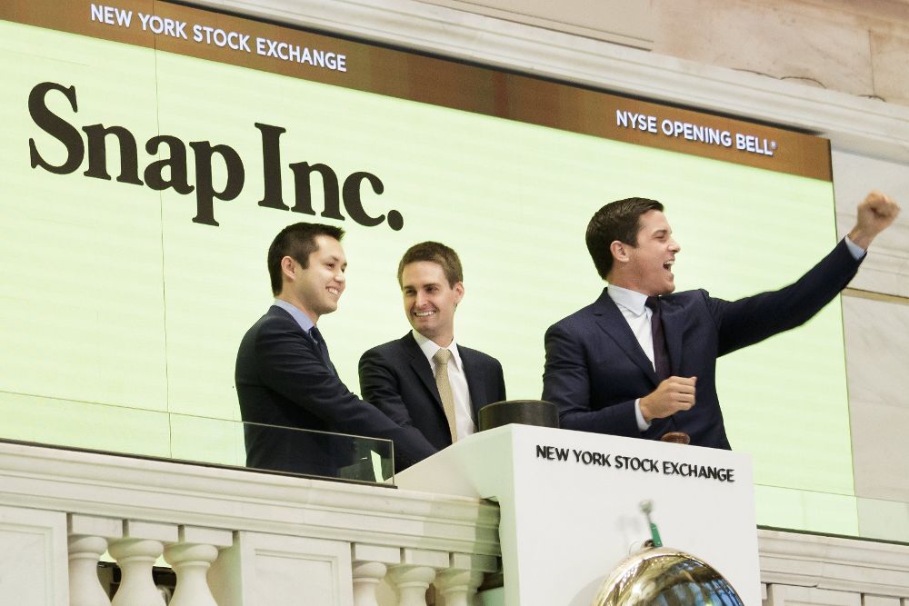 Los cofundadores de Snapchat, Bobby Murphy (i) y Evan Spiegel (c), hacen sonar la campana de apertura junto al presidente de la Bolsa de Nueva York, Thomas W. Farley (d).